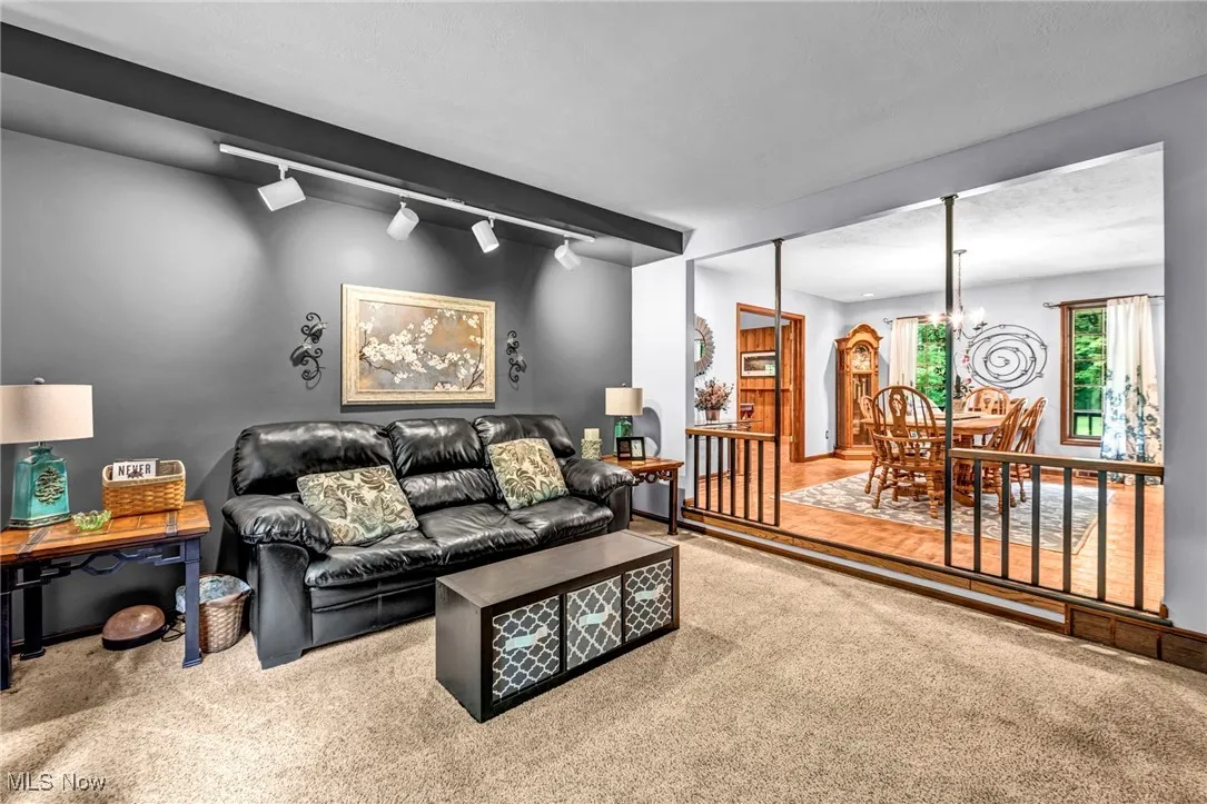 Carpeted living area with a chandelier and track lighting