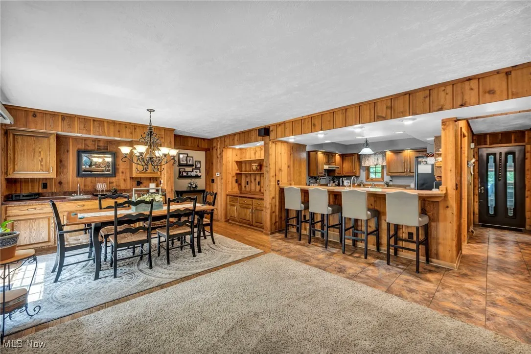 Dining area with wood walls and a chandelier