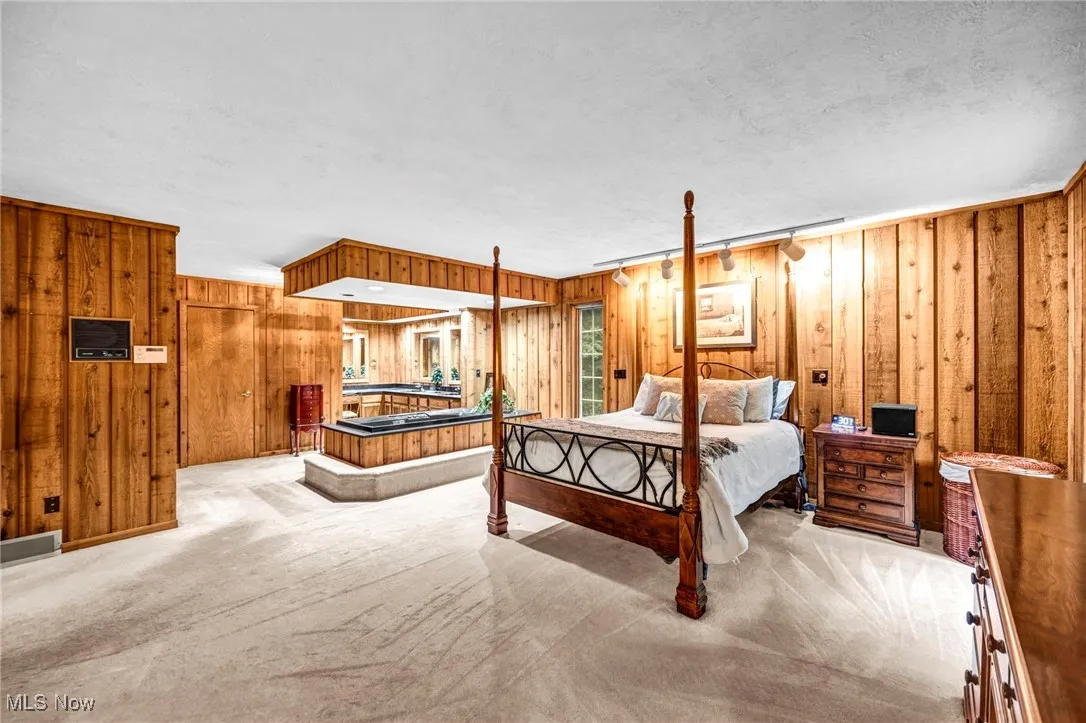 Carpeted bedroom featuring wood walls and a textured ceiling