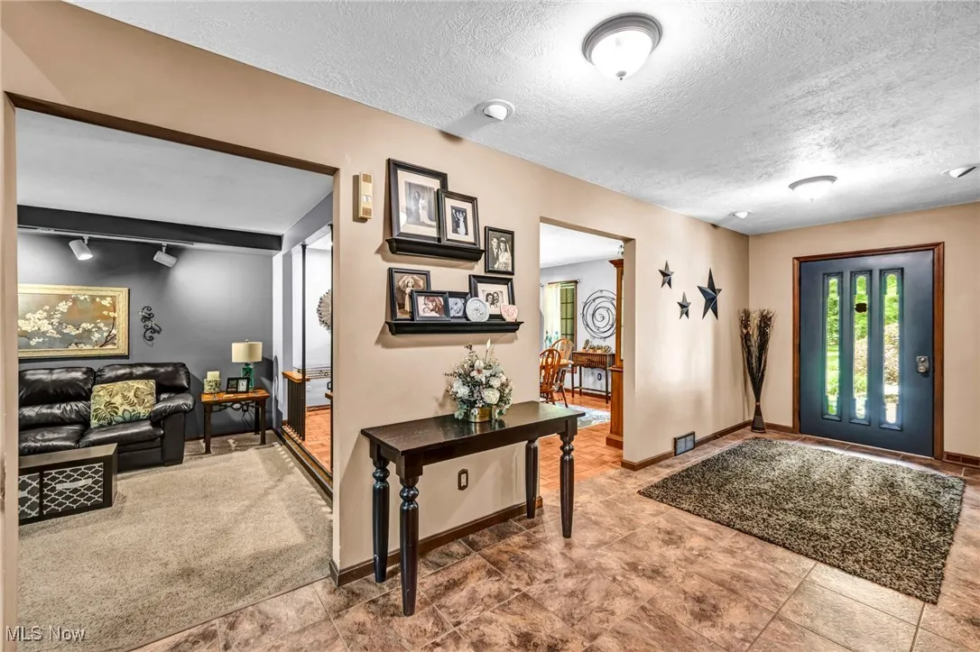 Foyer with a textured ceiling and baseboards