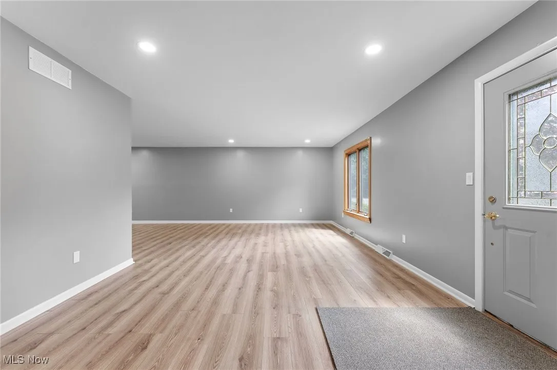 Foyer entrance with light wood-style floors and recessed lighting