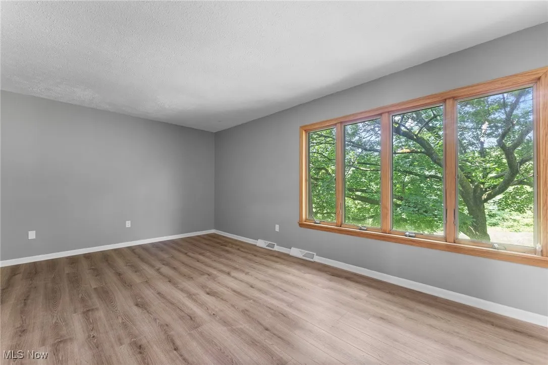 Empty room with wood finished floors and a textured ceiling