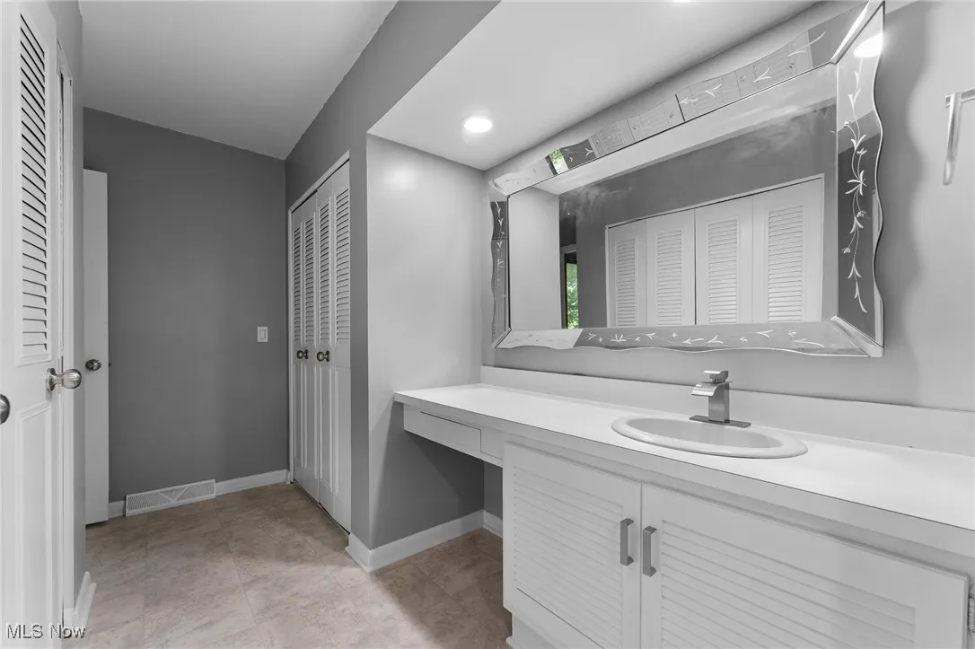 Bathroom featuring a closet and vanity