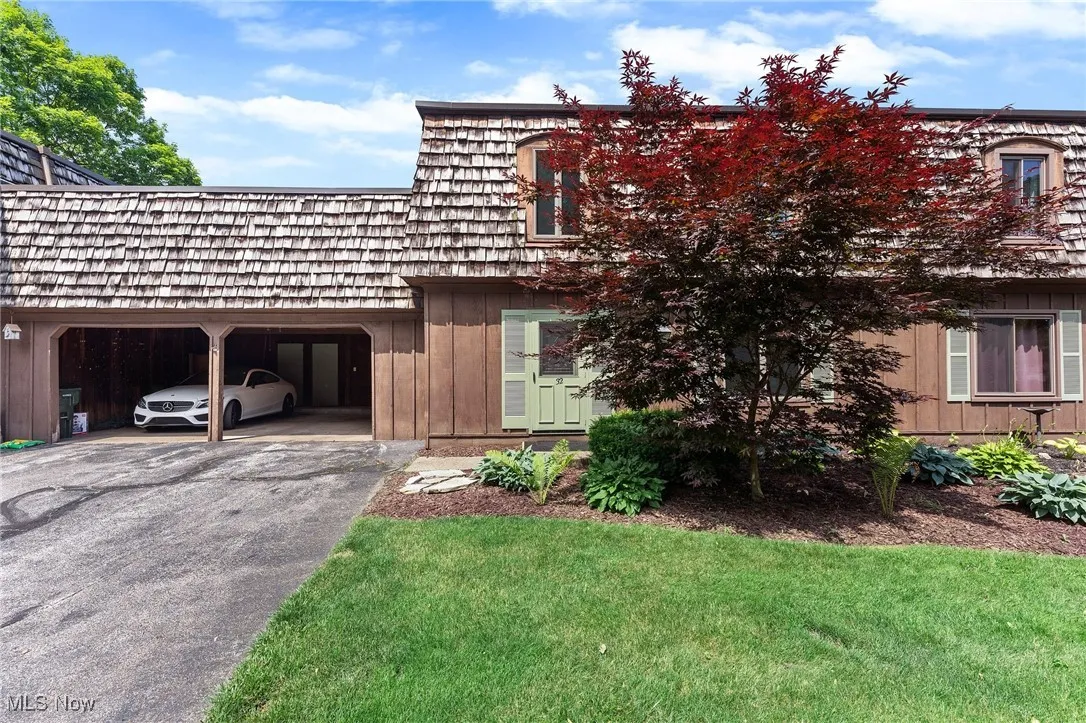 View of front of property featuring driveway, board and batten siding, and a front yard