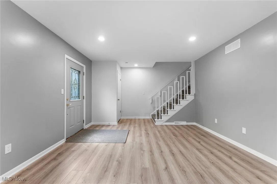 Foyer with recessed lighting, light wood-style flooring, and stairway