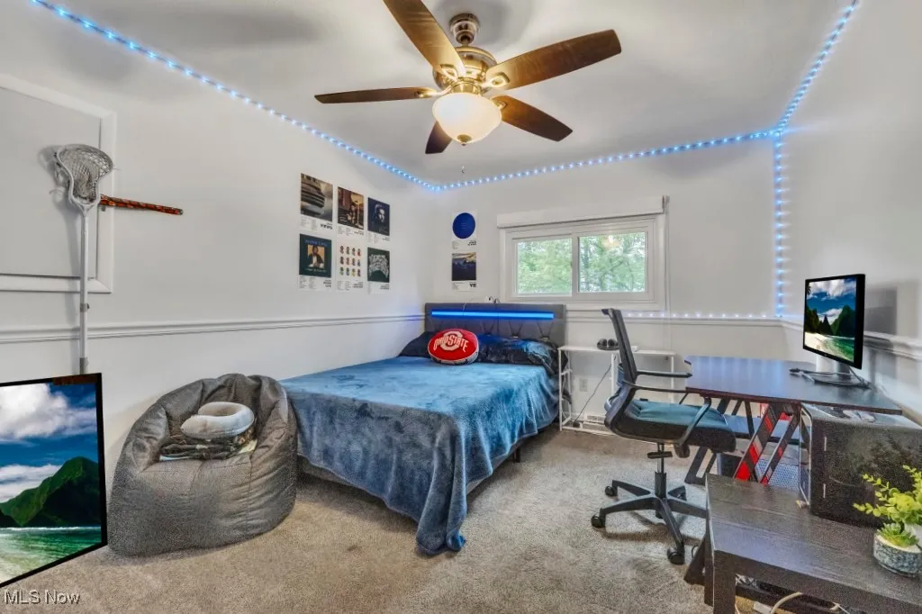 Carpeted bedroom featuring a ceiling fan