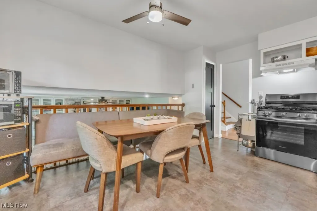 Dining room with a ceiling fan and stairs
