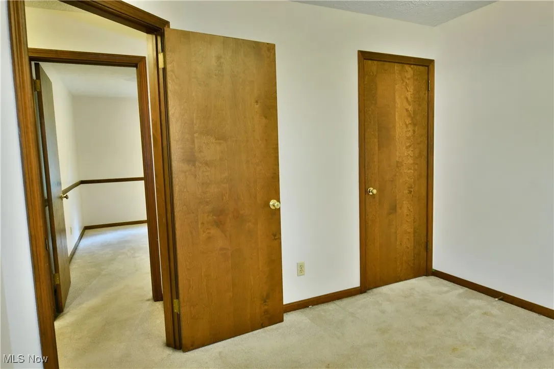 Unfurnished bedroom with carpet floors and baseboards
