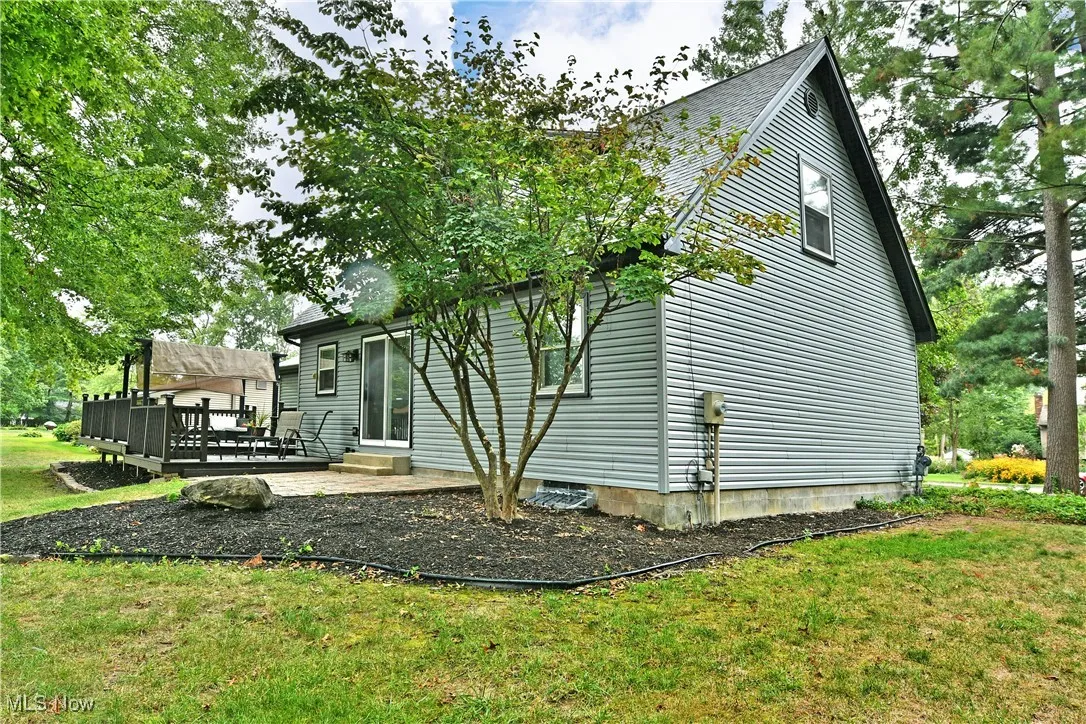 Back of property with a wooden deck and a yard
