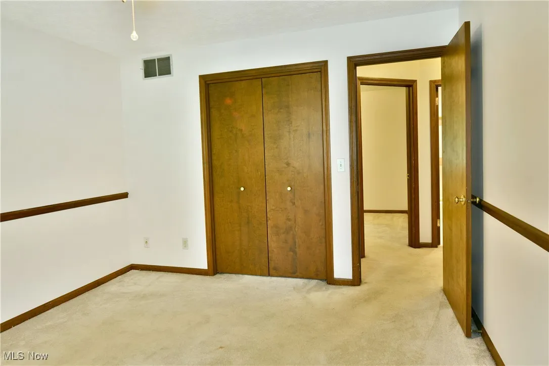 Unfurnished bedroom featuring light carpet and a closet