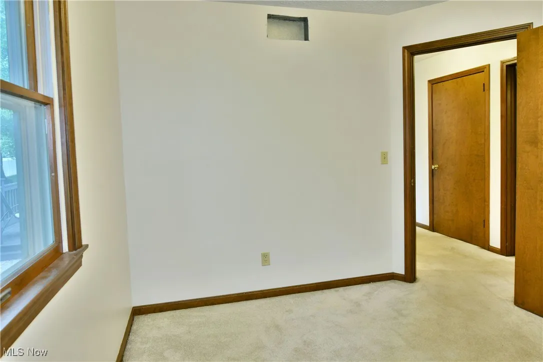 Unfurnished room with carpet flooring and baseboards