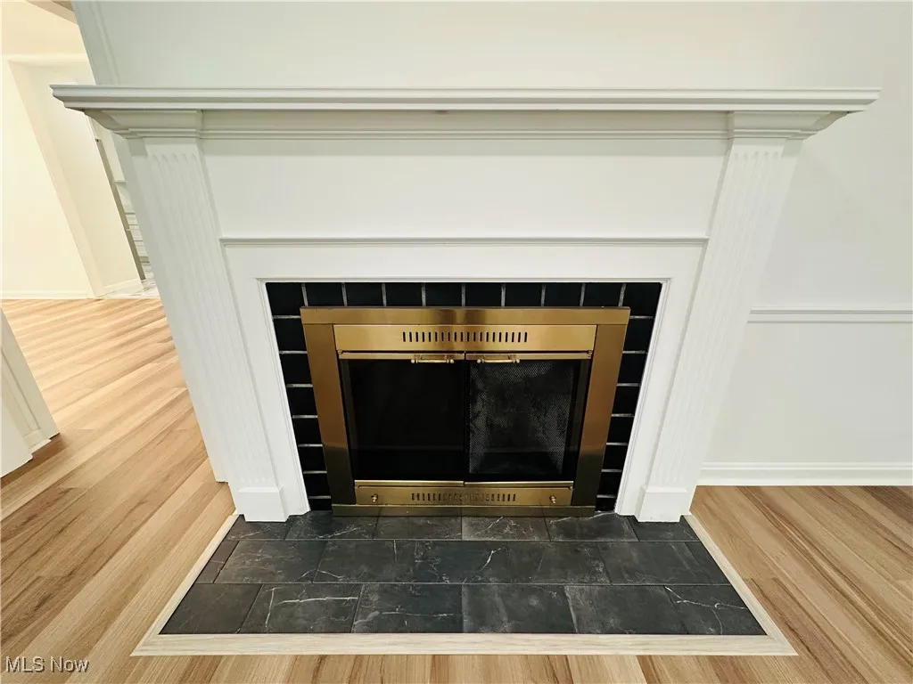 Detailed view of luxury vinyl floors and a tile fireplace