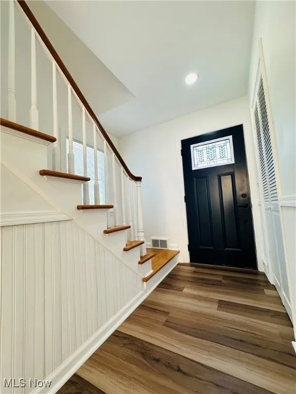 Entryway with stairs, wood finished floors, and recessed lighting