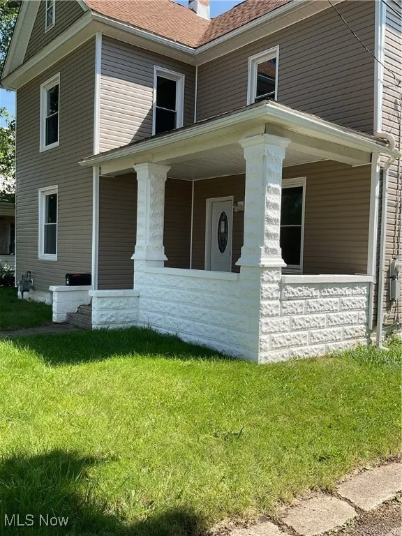 View of front of house featuring a porch, a front lawn, and roof with newer shingles