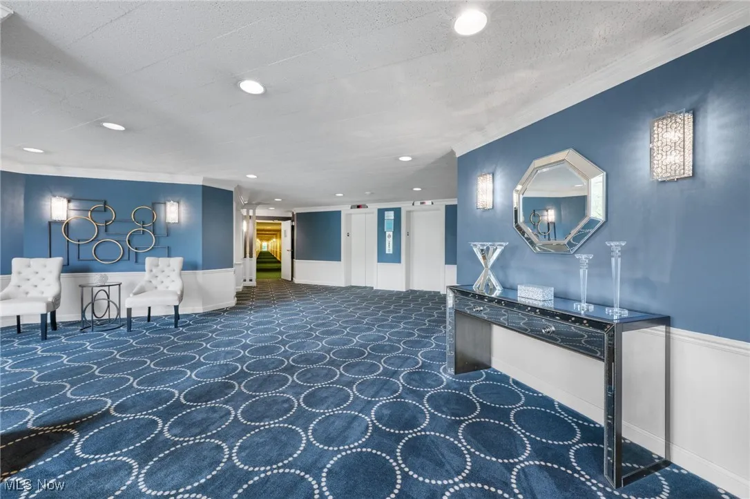 Common area featuring ornamental molding, a wainscoted wall, and recessed lighting