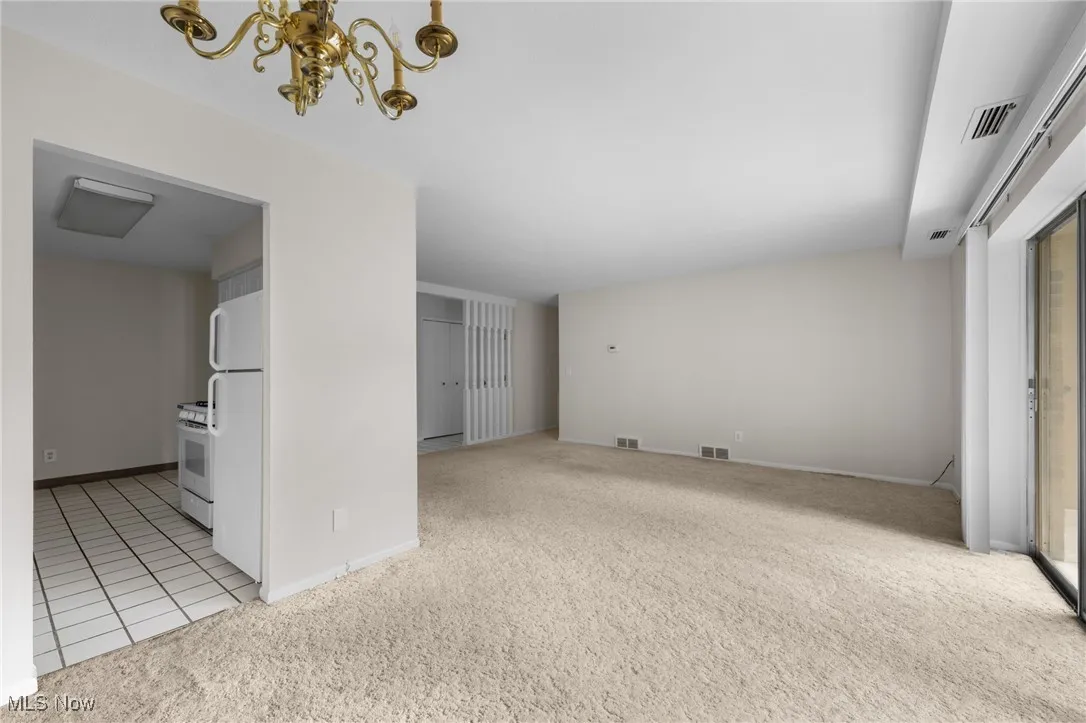 Unfurnished living room with light carpet, and access to balcony