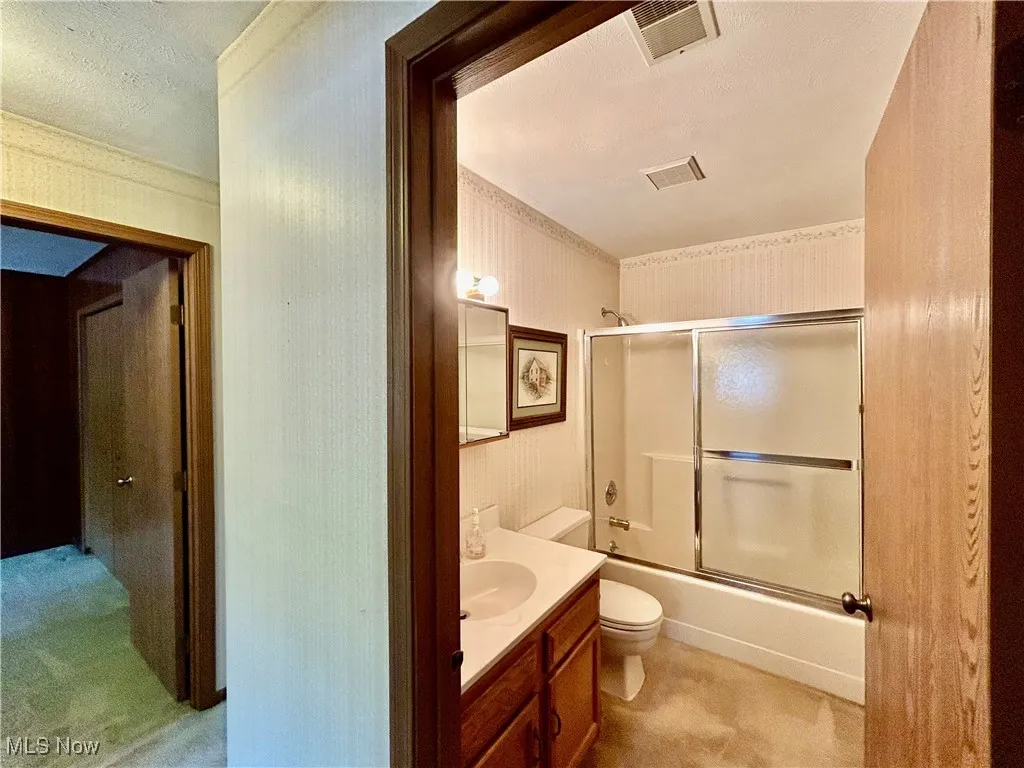 Full bath with vanity and enclosed tub / shower combo
