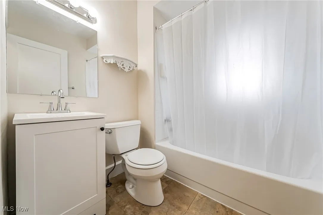 Full bathroom featuring vanity and shower / bath combo with shower curtain