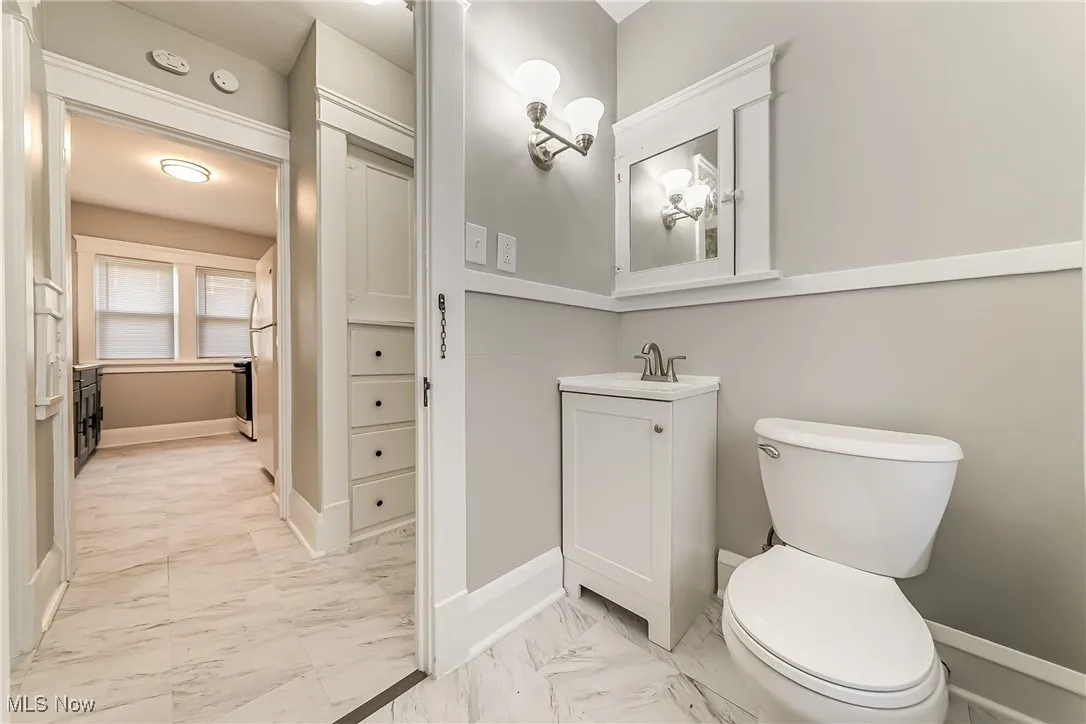 Bathroom with marble look tile flooring and vanity