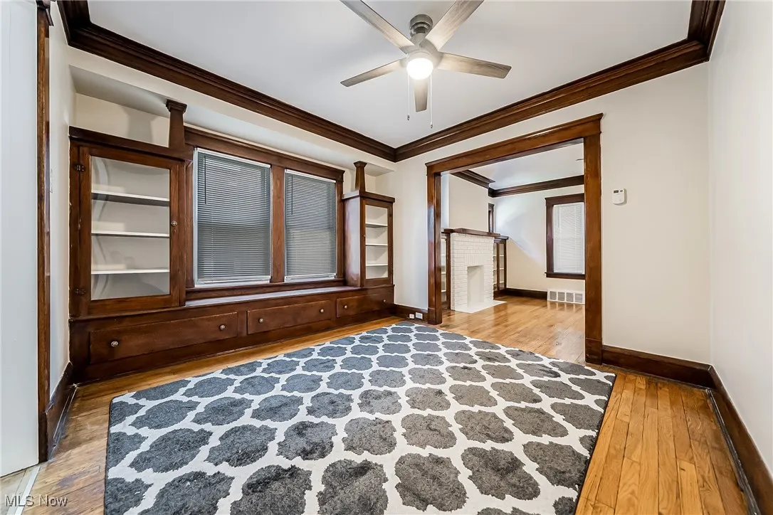 Unfurnished room with ornamental molding, light wood finished floors, and a ceiling fan