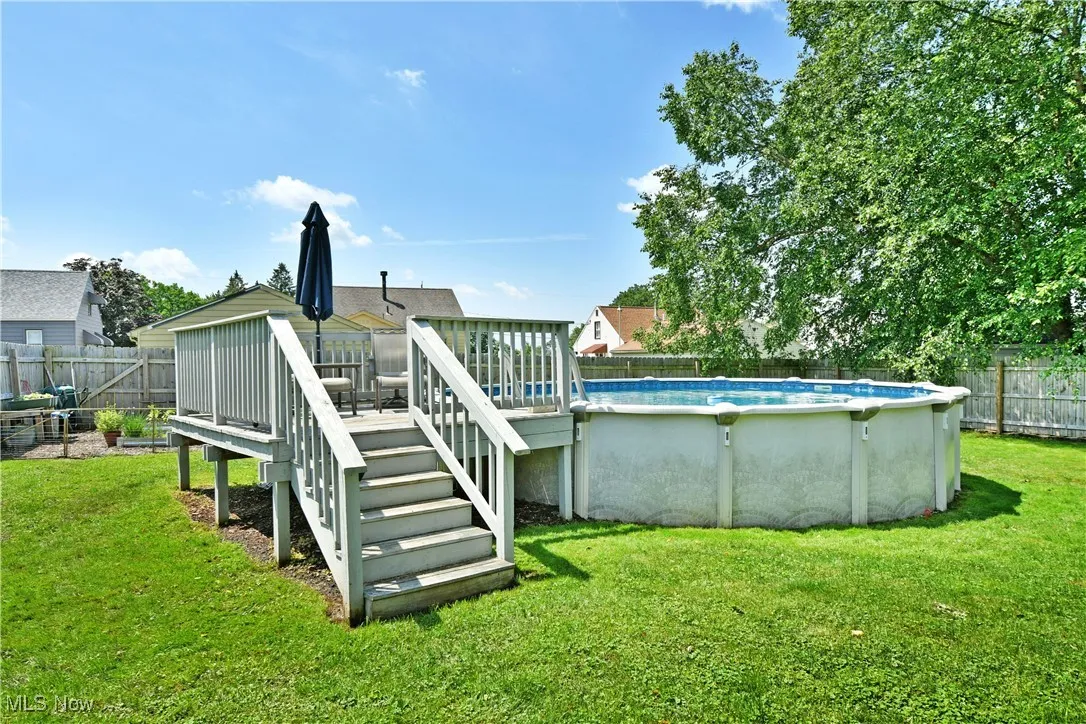 View of swimming pool featuring a wooden deck and a fenced backyard