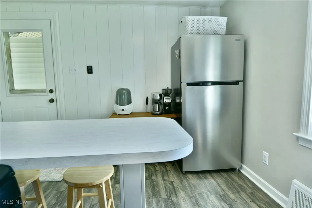 Kitchen with freestanding refrigerator and wood finished floors