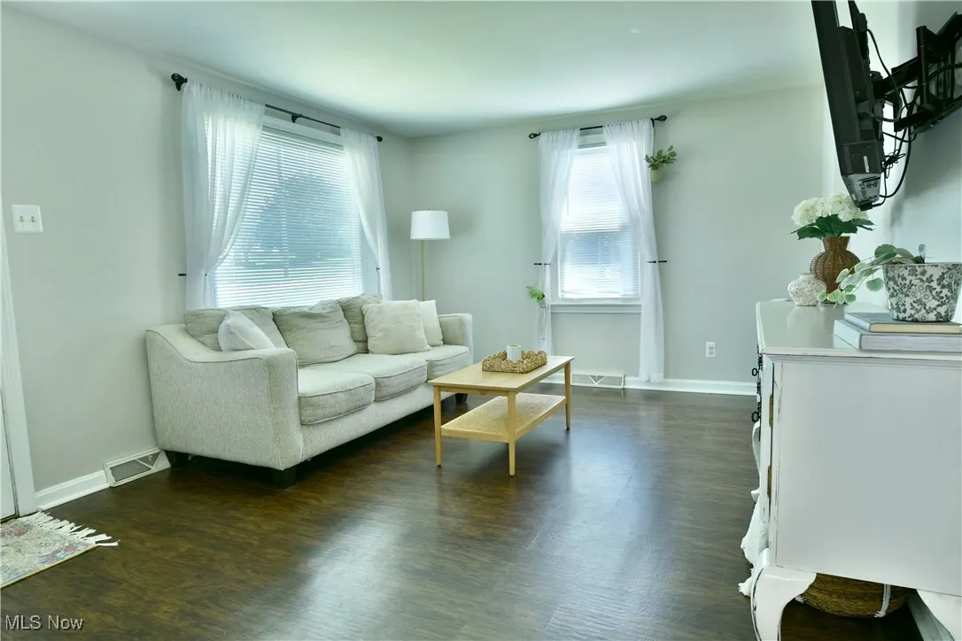 Living area featuring dark wood finished floors and baseboards