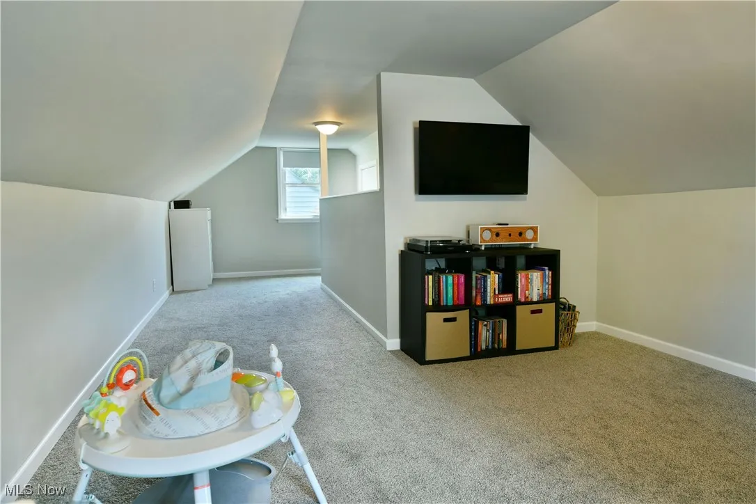 second floor bedroom featuring carpet and lofted ceiling