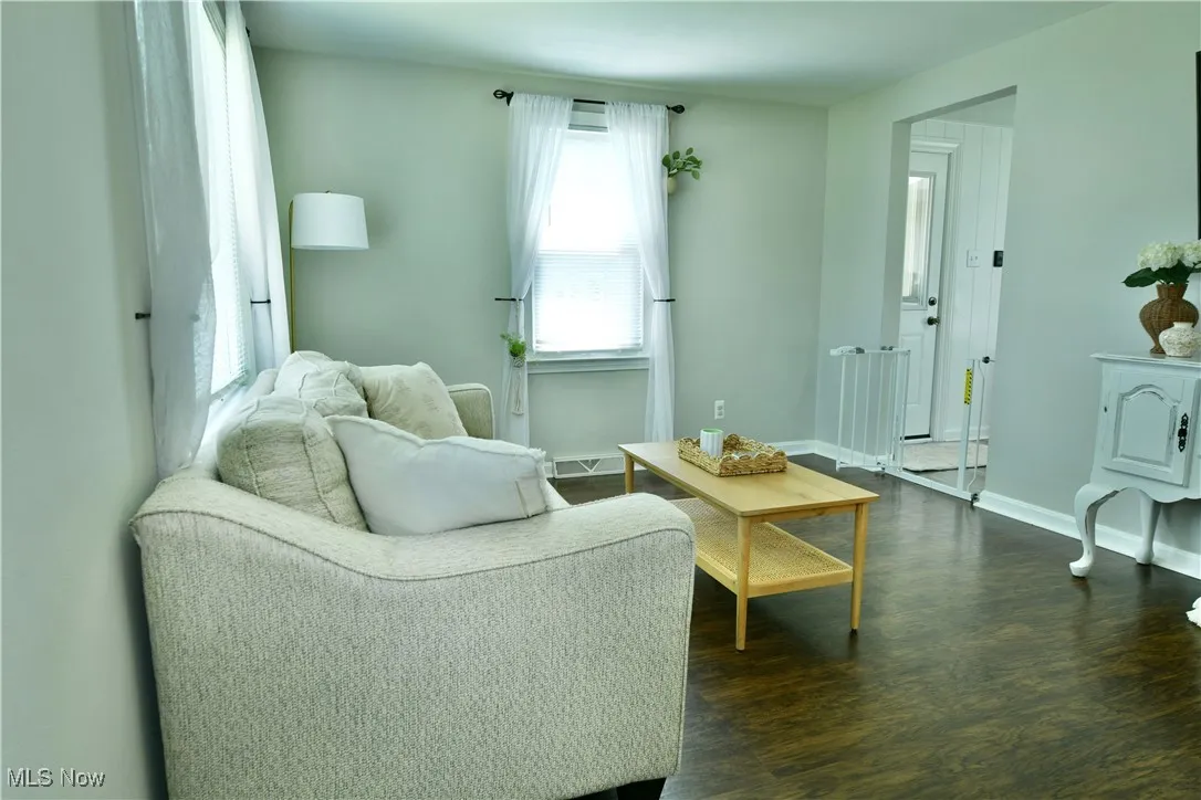 Living area with dark wood-style floors and baseboards