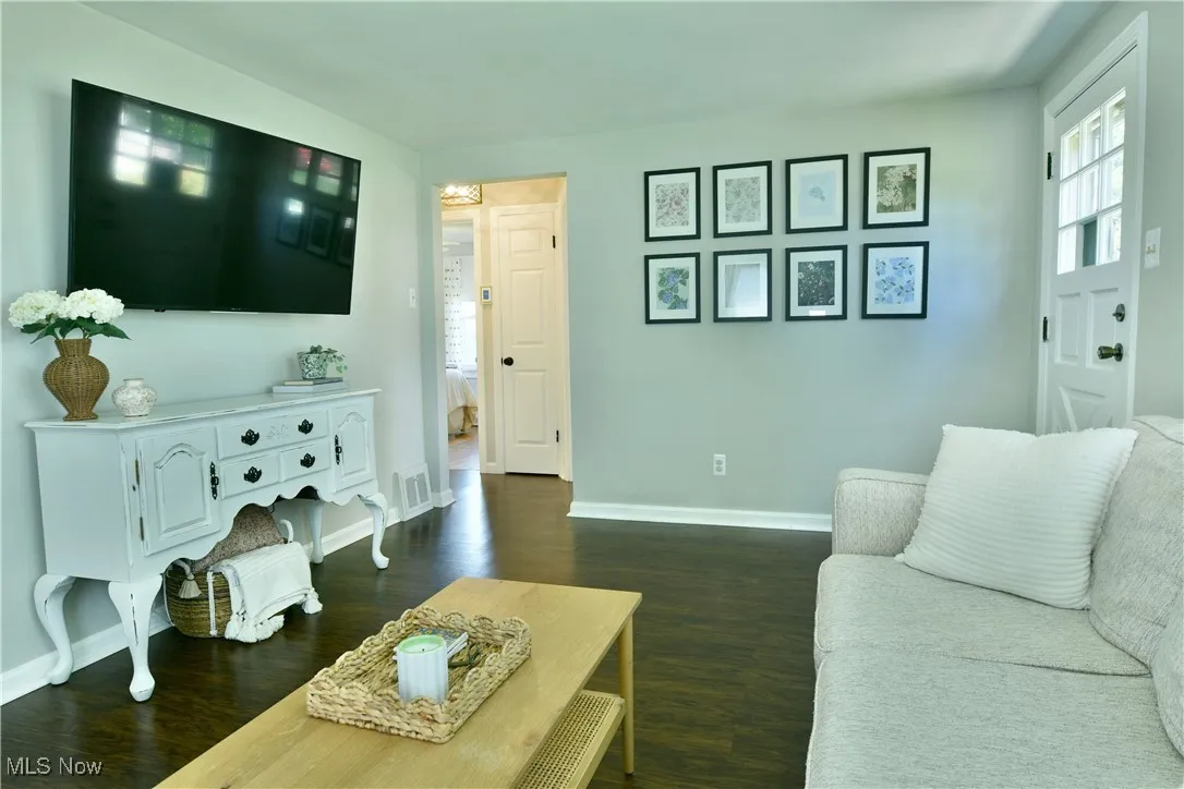Living area featuring dark wood finished floors and baseboards