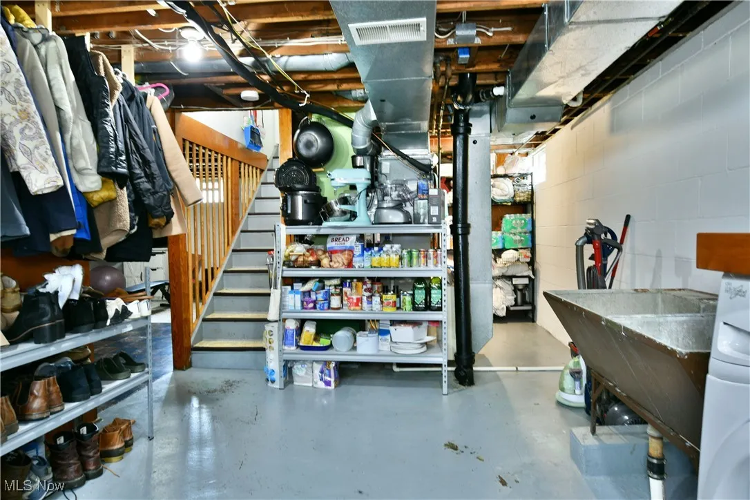 Unfinished below grade area with stairs and washer / dryer