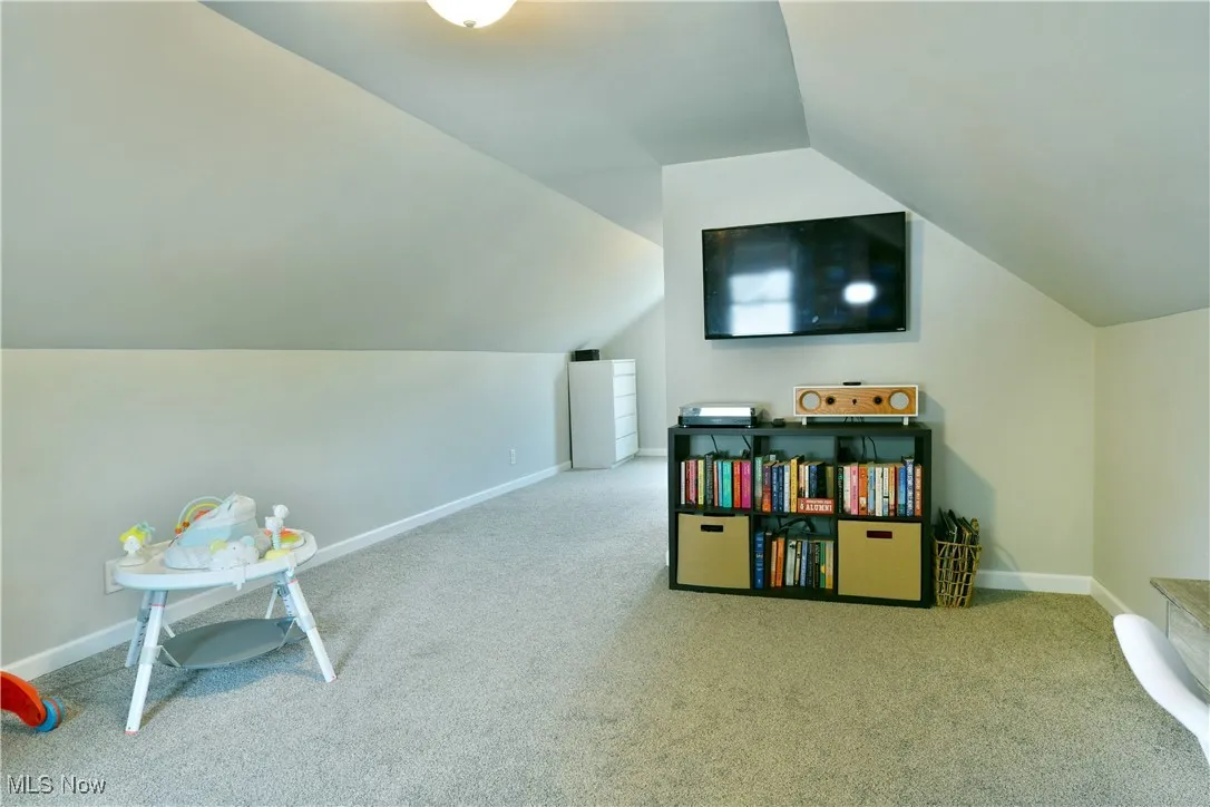 second floor bedroom featuring carpet and lofted ceiling