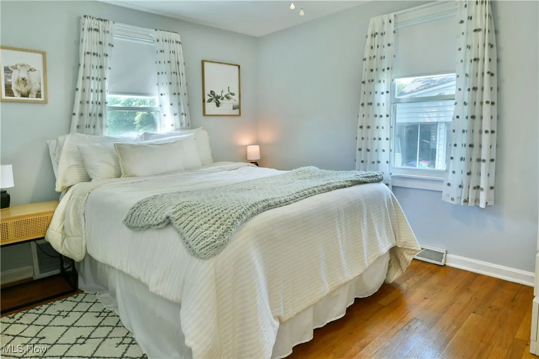 Bedroom with multiple windows and wood-type flooring