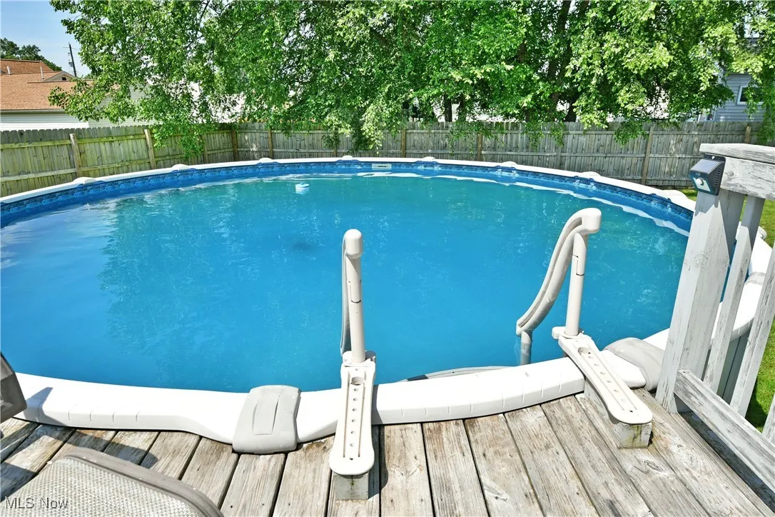 View of swimming pool featuring a fenced backyard and a deck