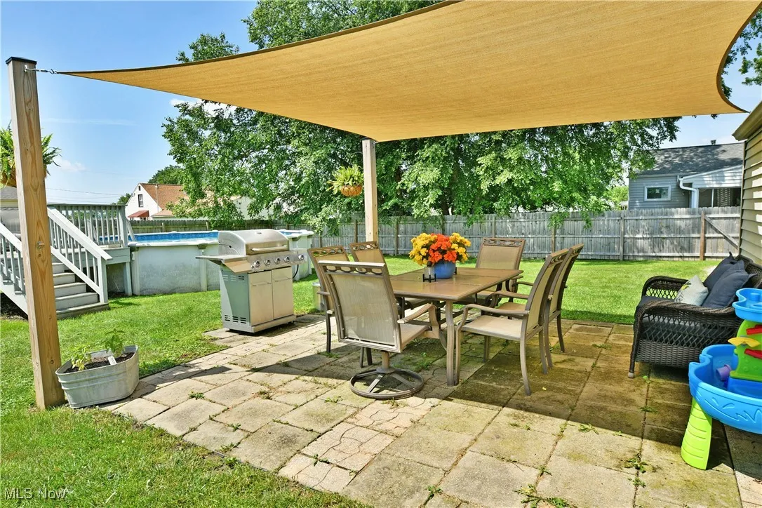 Fenced backyard featuring a patio, outdoor dining area, area for grilling, and stairs