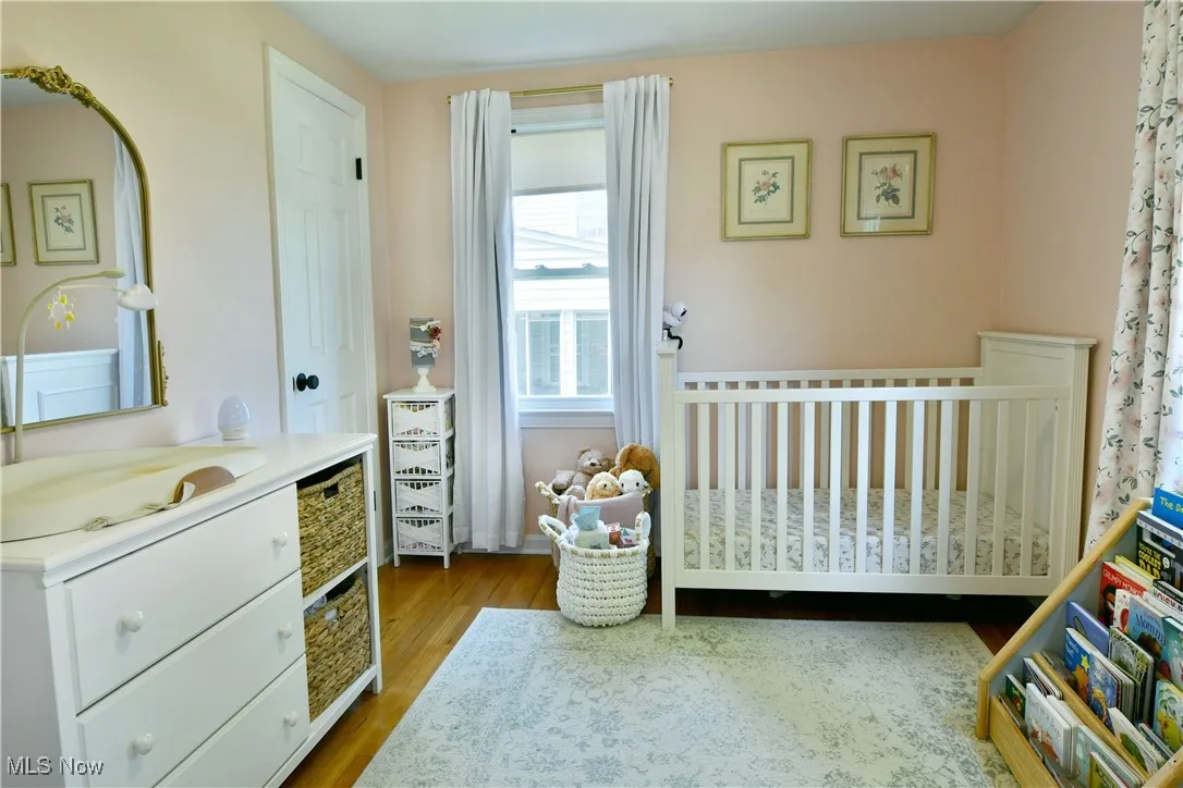 Bedroom featuring a crib and wood finished floors