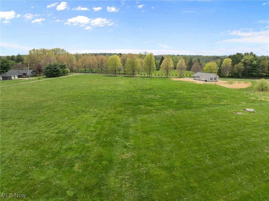 View of grassy yard featuring a view of rural / pastoral area and a view of trees