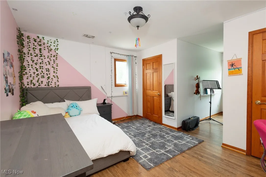 Bedroom with wood finished floors and baseboards