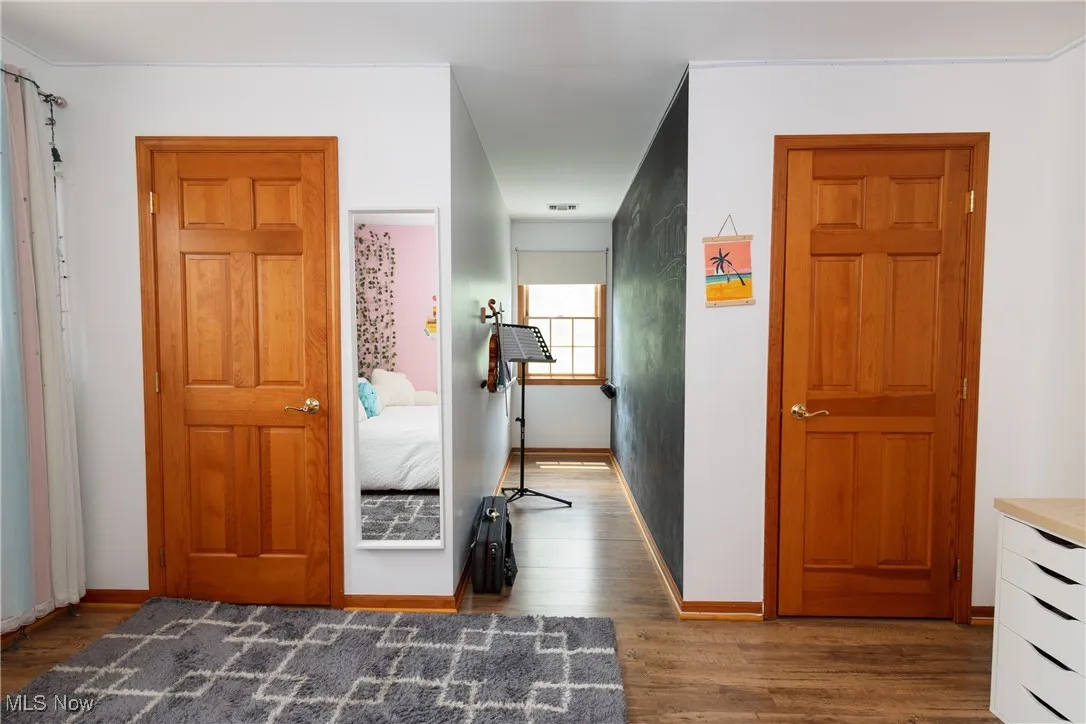 Bedroom with hardwood floors and baseboards