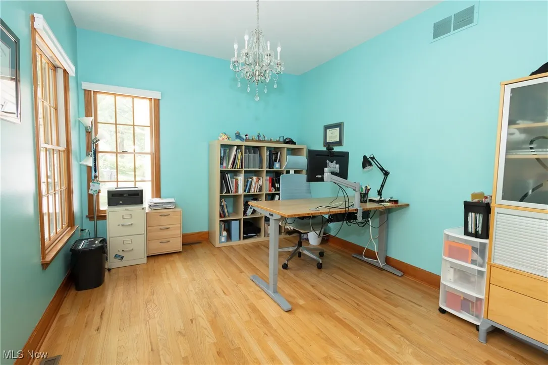Office with hardwood floors and a chandelier