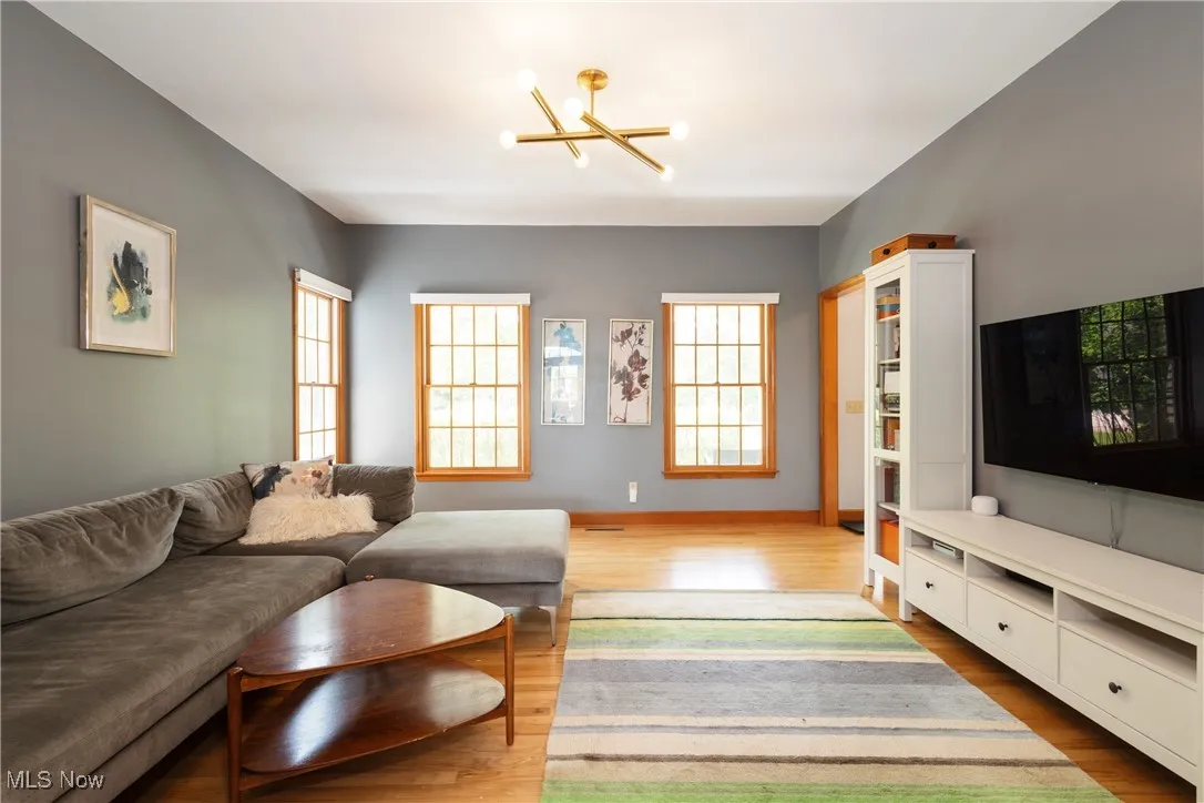 Living room featuring a chandelier, plenty of natural light, and wood finished floors