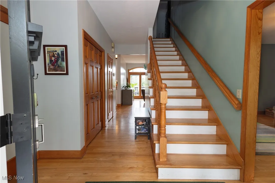Foyer with hardwood floors and stairway.