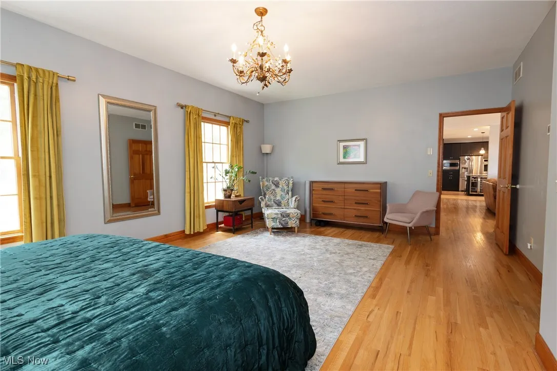Bedroom with a chandelier, and hardwood floors