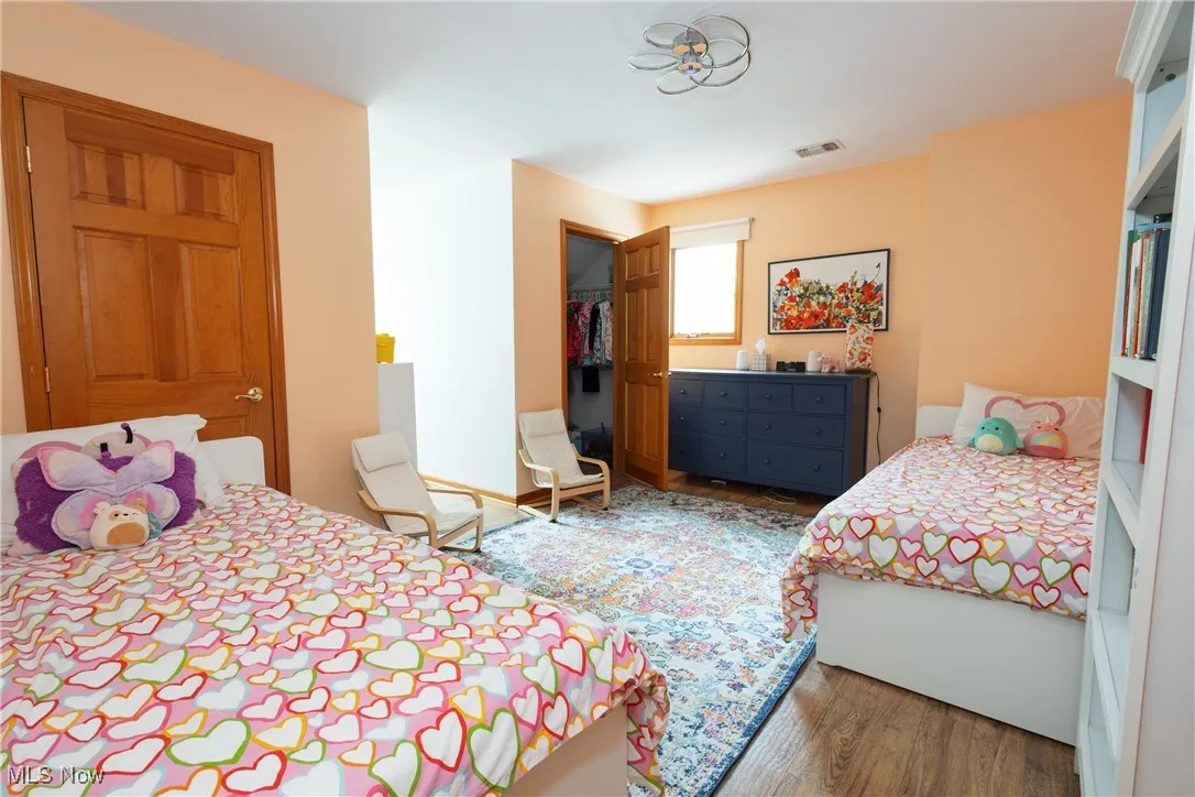 Bedroom with wood finished floors and a closet
