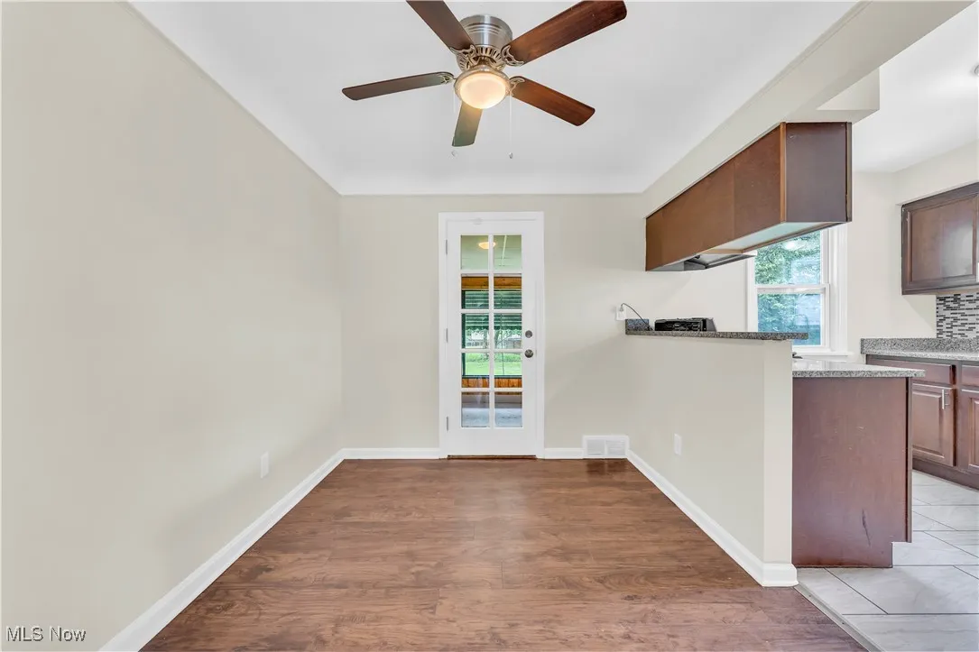 Kitchen featuring light wood-type flooring, ceiling fan, light countertops, and a peninsula