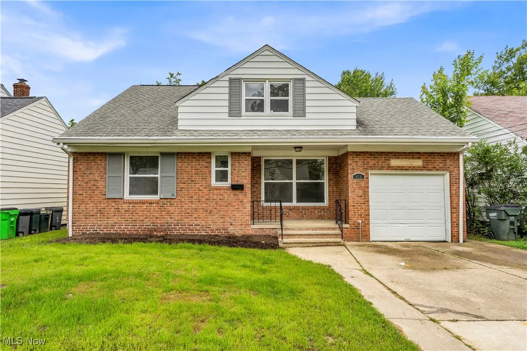 Bungalow-style home featuring brick siding, concrete driveway, a front yard, and a garage