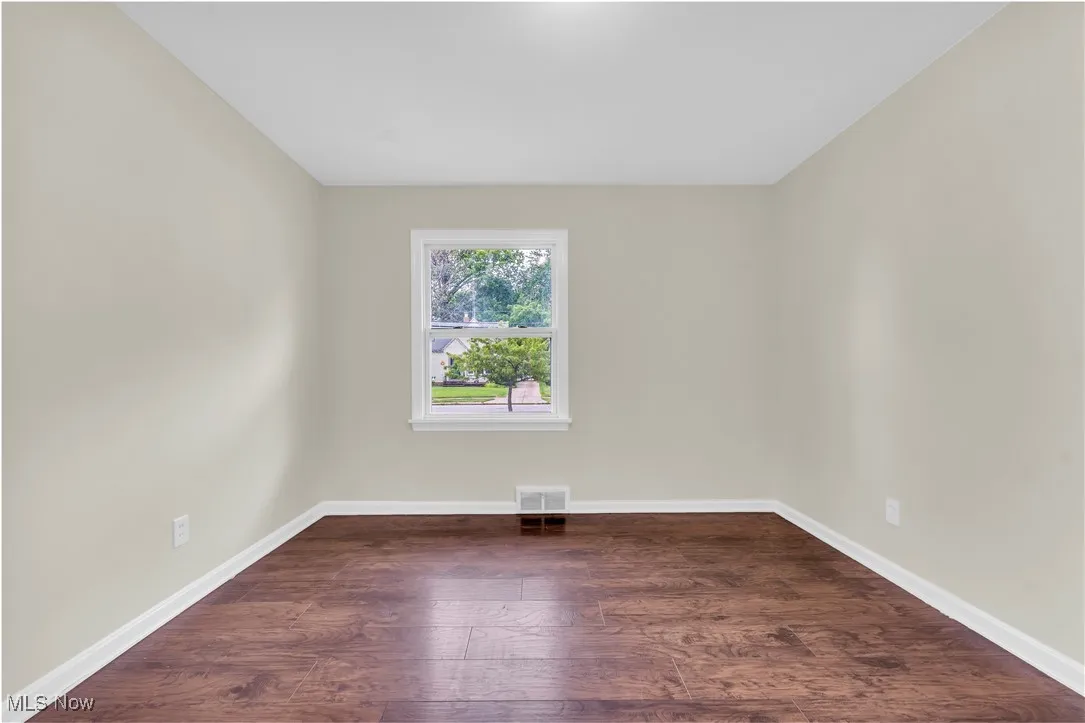 Unfurnished room featuring wood finished floors and baseboards
