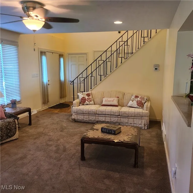 Living area featuring carpet, stairs, recessed lights, and ceiling fan