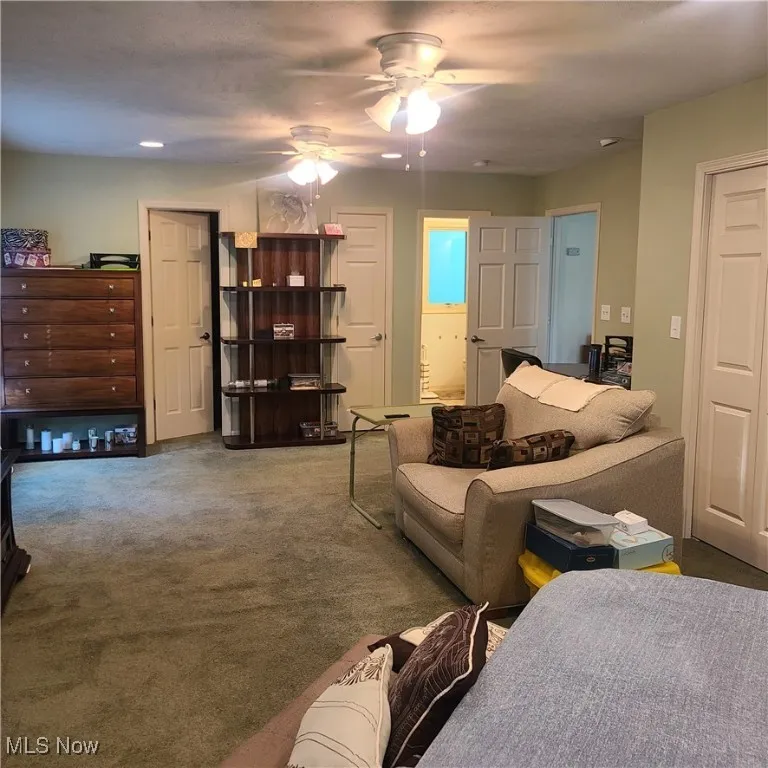 Master Bedroom living area featuring 2 of 3 ceiling fans and carpet flooring, entry to Master Bath and Walk-in closet