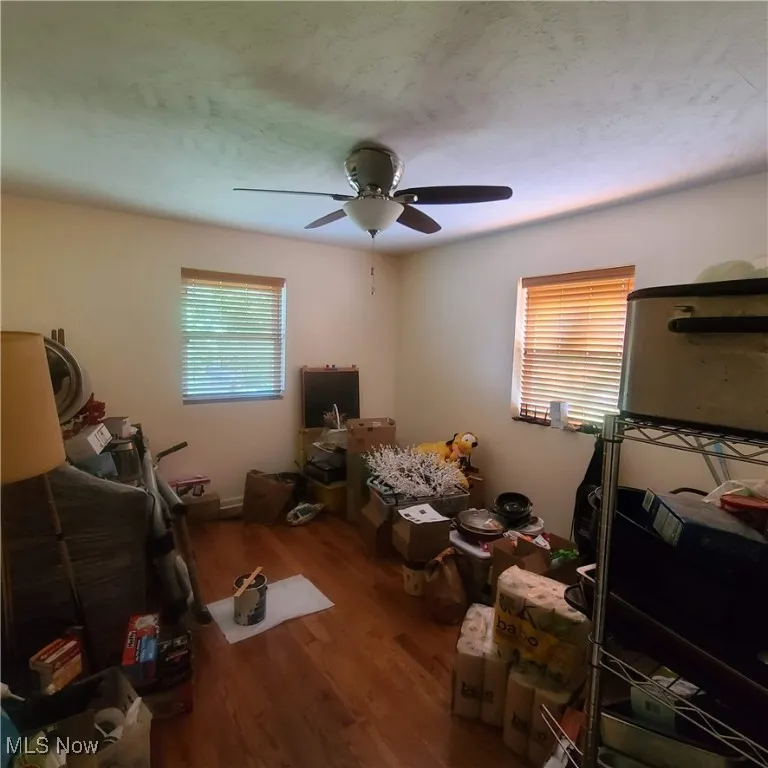 Bedroom on main floor featuring wood finished floors and a ceiling fan